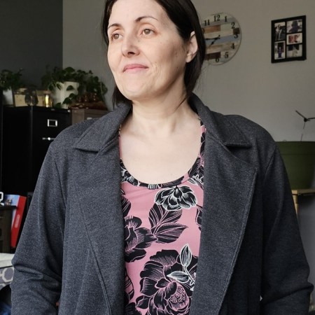 Photo of Kristin in her newly sewn Jalie Cardigan. She is smiling and looking off in the distance.